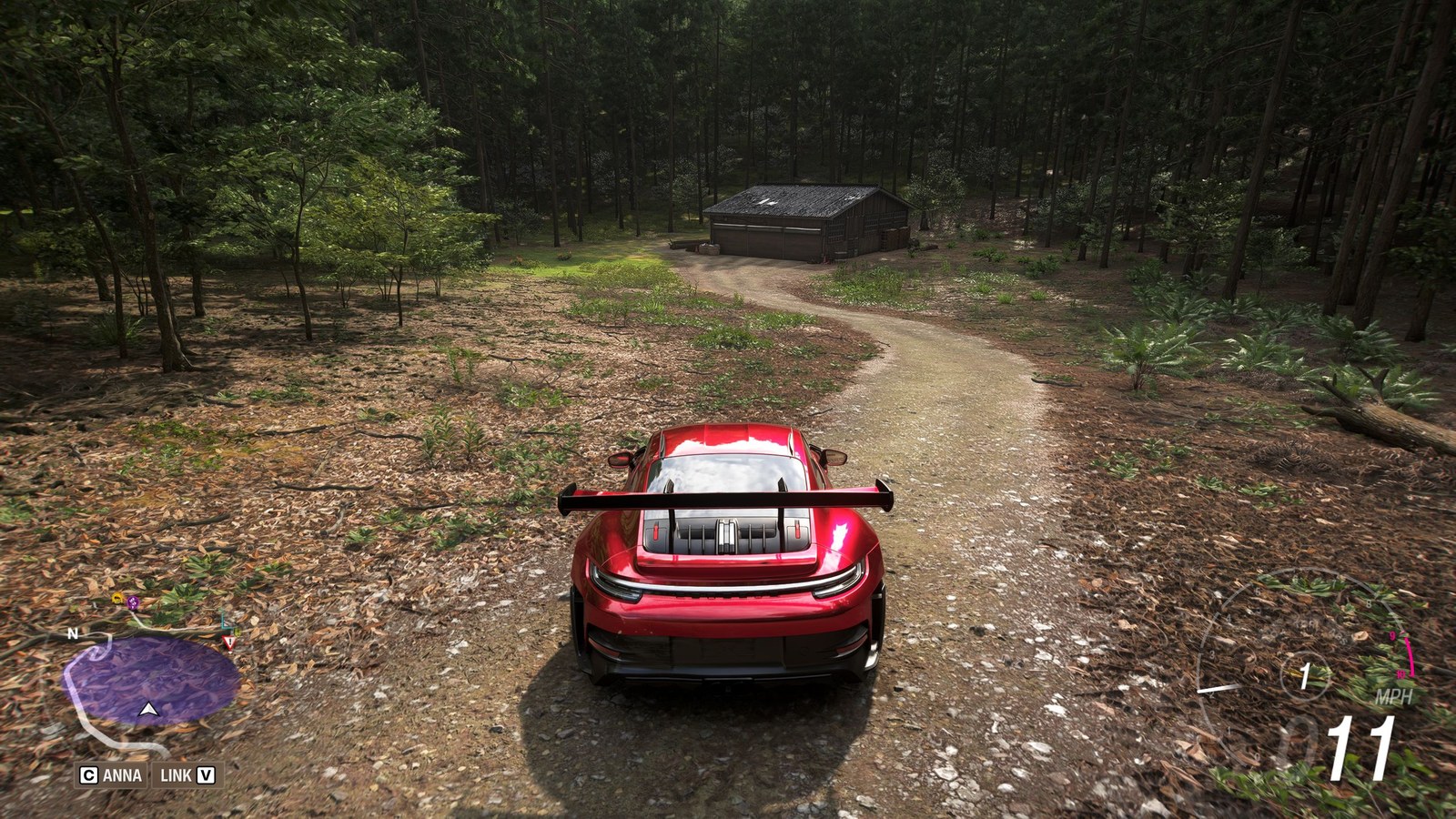 Forza Horizon 6 Barn Finds: A player parked on a dirt path ahead of an old barn in a forest.