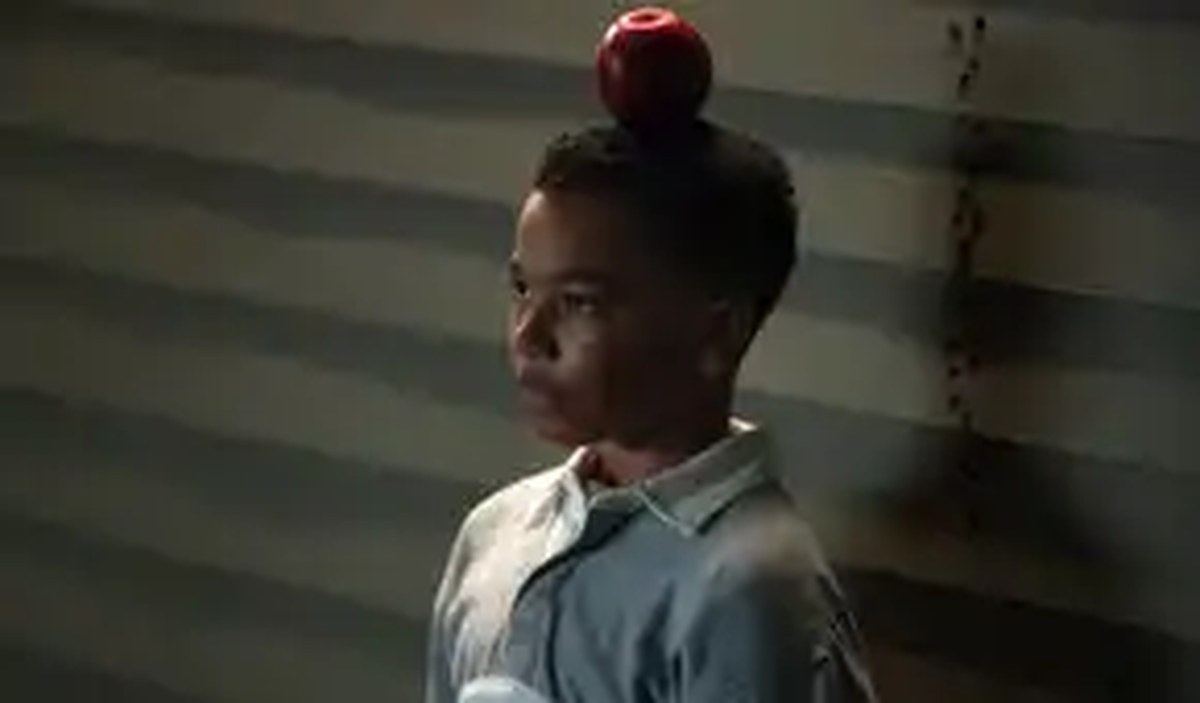 A young John Stewart (Cairo Cash Lee) stands with an apple balanced on his head in Lanterns
